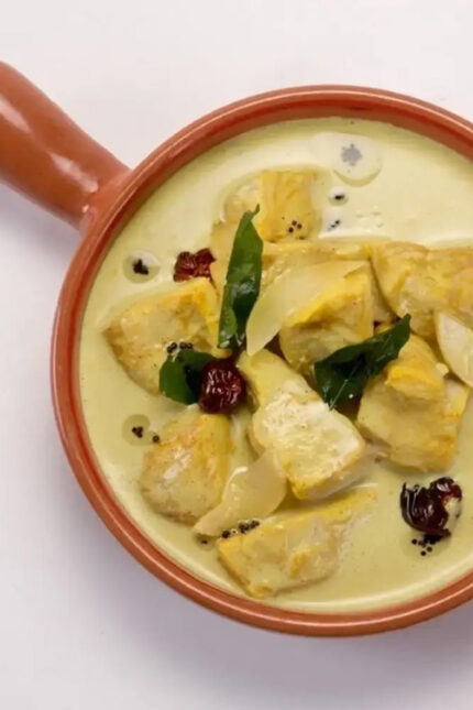 Aromatic South Indian Alleppey fish curry with coconut milk in a clay serving dish.