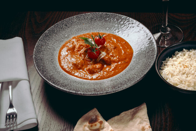 A fresh bowl of classic Chicken Tikka Masala curry with fresh coriander garnish.