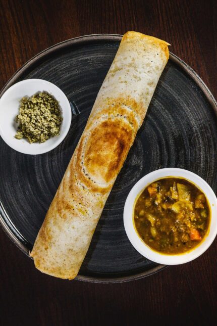 Crispy South Indian dosa served with traditional lentil sambar at Zari vegan restaurant.
