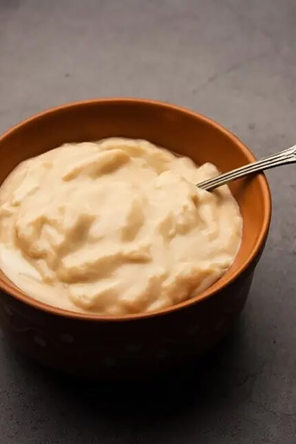 Thick sweet Mishti Doi yogurt dessert in a traditional clay pot at Zari Crawley.