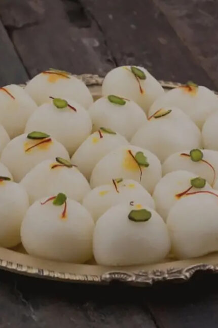 White syrup-filled Rasgulla dumplings garnished with pistachio at Zari Restaurant.