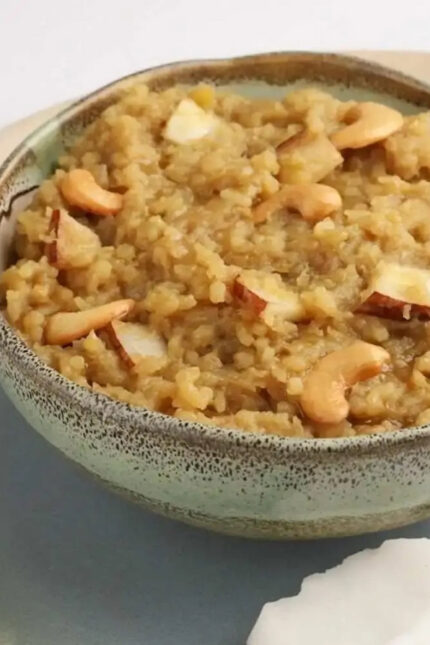 A bowl of traditional South Indian sweet pongal garnished with roasted cashew nuts.