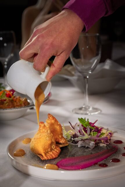 Gourmet samosas served with fresh salad and poured chutney at Zari Restaurant in Crawley.